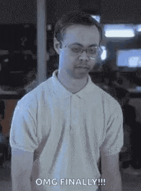 a man wearing glasses and a white shirt is standing in a room and says `` omg finally '' .