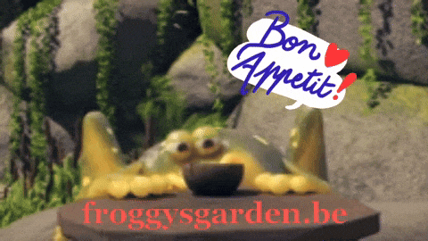 a frog sits on a table with a sign saying bon appetit