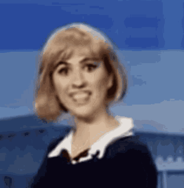 a woman with blonde hair is smiling and wearing a black shirt
