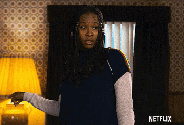 a woman is standing in a room with a netflix logo on the bottom right