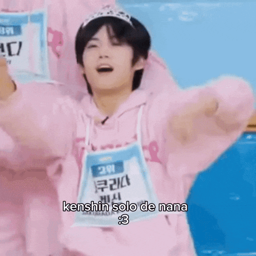 a person wearing a pink hoodie and a tiara is making a peace sign with their hand .