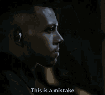 a close up of a man 's face with the words `` this is a mistake '' written on it .