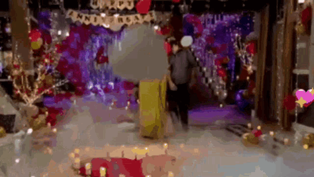 a man and woman are standing in front of a stage decorated for a christmas party .
