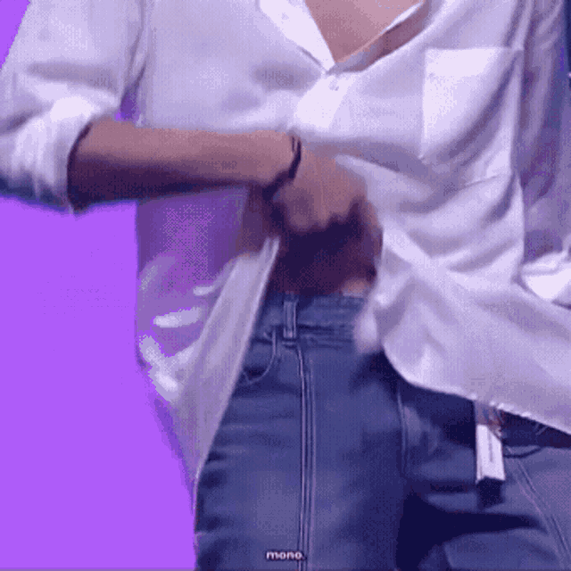 a man in a white shirt and blue jeans has the word mono on the bottom of his shirt
