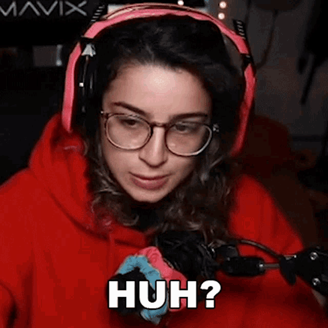 a woman wearing headphones and glasses is making a huh ? facial expression .