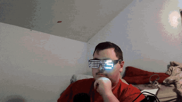 a man in a red shirt is wearing a pair of glowing glasses