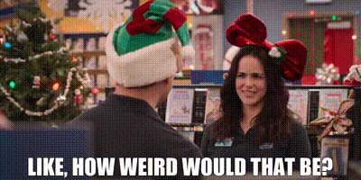a man and a woman are talking in front of a christmas tree .