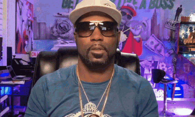 a man wearing sunglasses and a hat is sitting in a chair