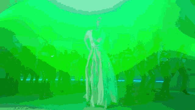 a woman in a white dress is dancing in a pink room .