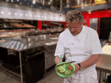 a chef is holding a bowl of food with chopsticks in a kitchen