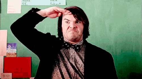 a man in a suit and bow tie is making a funny face in front of a chalkboard with the word subject written on it