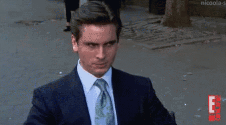 a man in a suit and tie is looking at the camera .