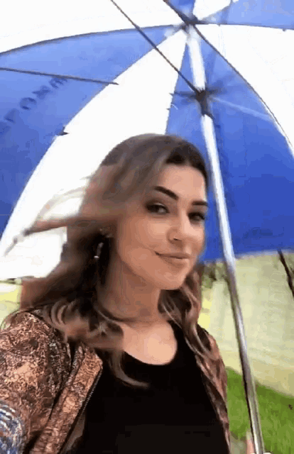 a woman is holding a blue and white umbrella that says tommy on it