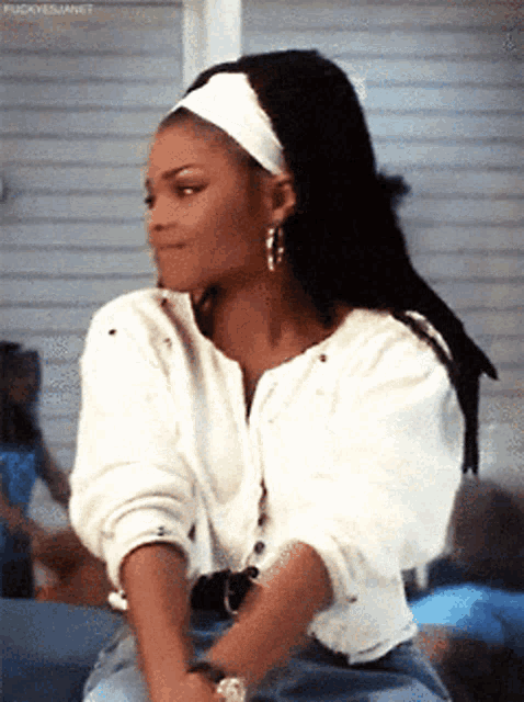 a woman with dreadlocks wearing a white headband and a white shirt