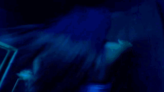 a blurry picture of a woman in a blue light .