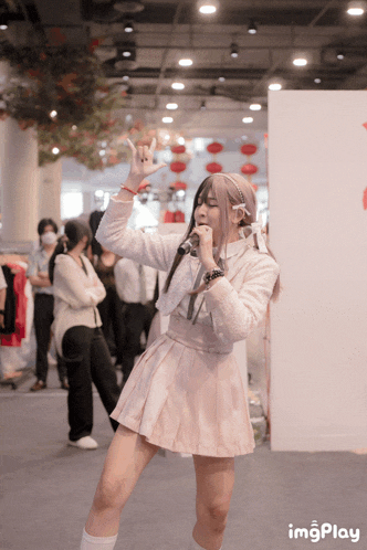 a girl singing into a microphone with imgplay written in the bottom right corner