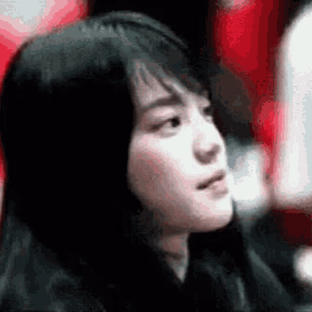 a close up of a woman 's face with a blurry background .