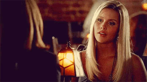 a woman with blonde hair is talking to another woman in a restaurant .