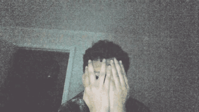 a man is covering his face with his hands