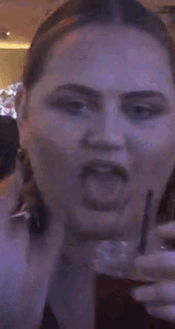 a close up of a woman 's face with a purple light behind her