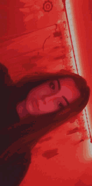 a girl is taking a selfie in front of a red curtain