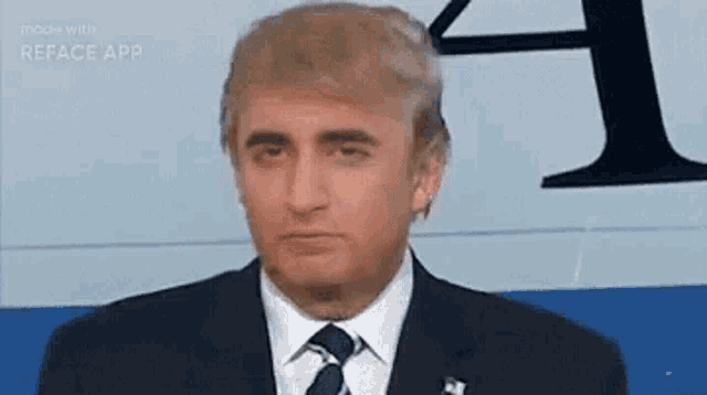 a man in a suit and tie is wearing a fake donald trump face .