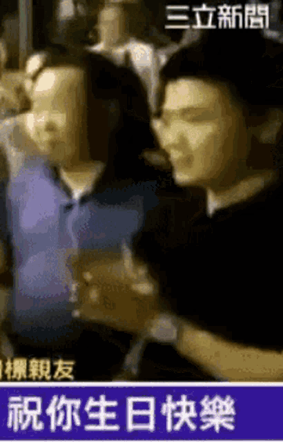 a man and a woman are hugging each other in a crowd with chinese writing on the bottom