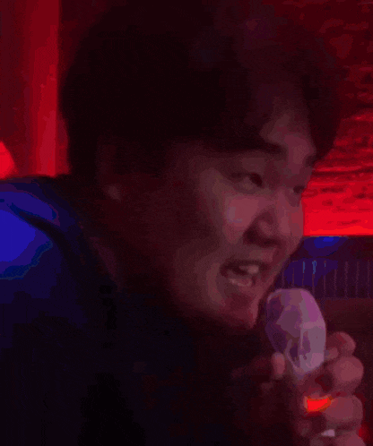 a man with his tongue hanging out is holding a remote control