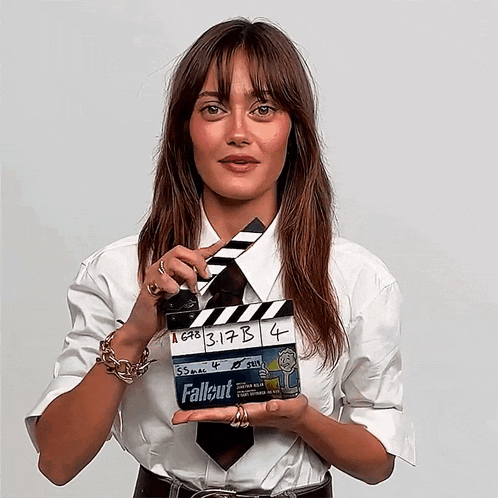 a woman holding a clapper board that says fallout