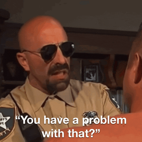 a man in a sheriff 's uniform talks to another man with the words " you have a problem with that "