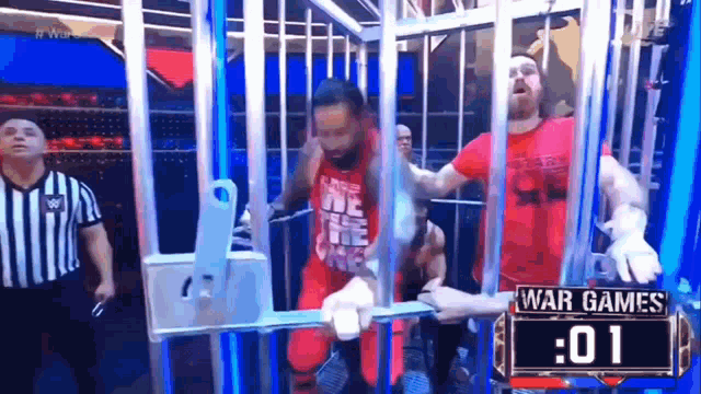 a group of men are standing in a cage on a stage .