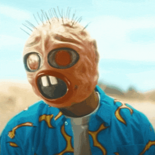 a man wearing a gas mask and a blue shirt with flames on the sleeves