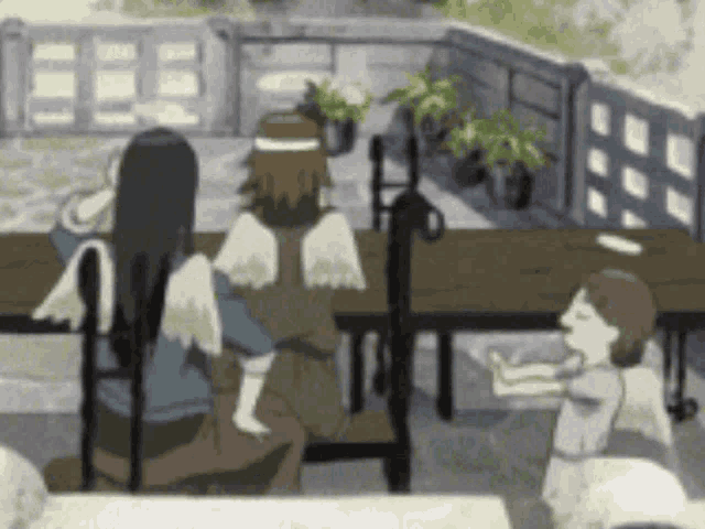 a group of people sitting at a table with angels on their heads