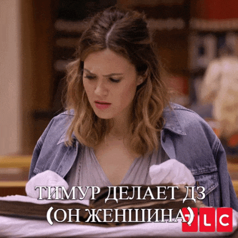 a woman in a denim jacket is looking at a book with lc written on the bottom