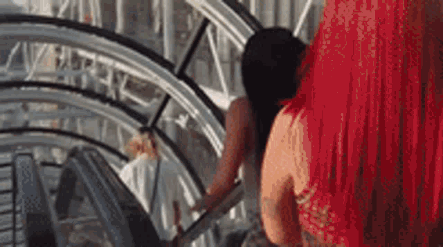 a woman with red hair is riding an escalator in a tunnel .