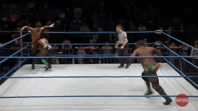 two wrestlers in a wrestling ring with a red circle that says axsco on it