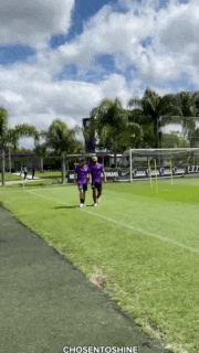 two people walking on a soccer field with chosentoshine written on the bottom right