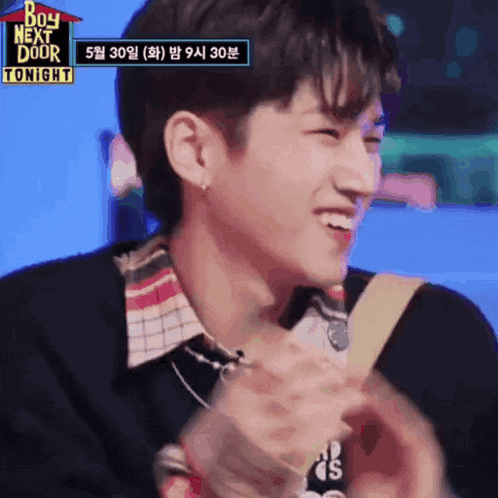 a young man is smiling in front of a sign that says ' boy next door tonight '