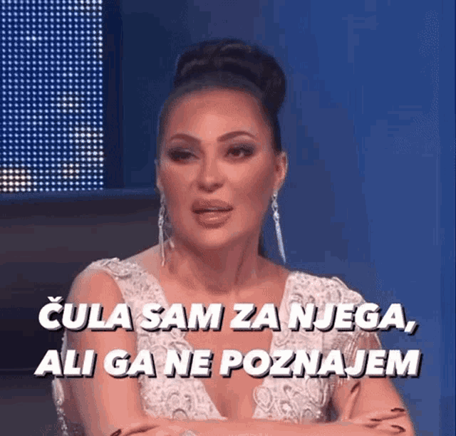 a woman in a white dress is sitting with her arms crossed and says cula sam za njega ali ga ne poznajem