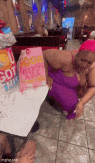 a woman in a purple dress is holding a pink gift bag that says " good things are coming "