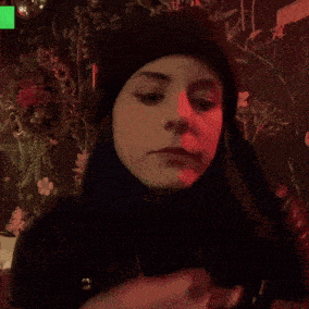 a woman with a nose ring is applying lipstick to her lips