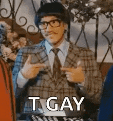 a man in a suit and tie is pointing at something and saying t gay .