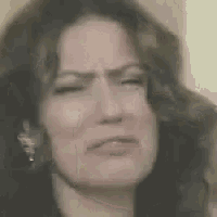 a woman is making a funny face in a blurry photo .