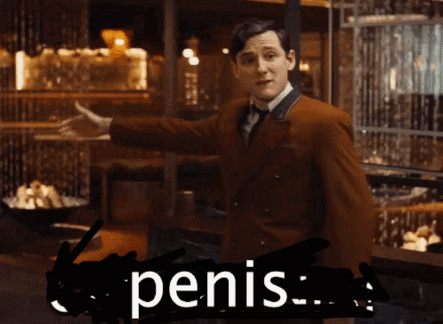 a man in a brown suit and tie is standing in front of a sign that says penis