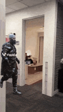 a man dressed as god of war is walking through a hallway