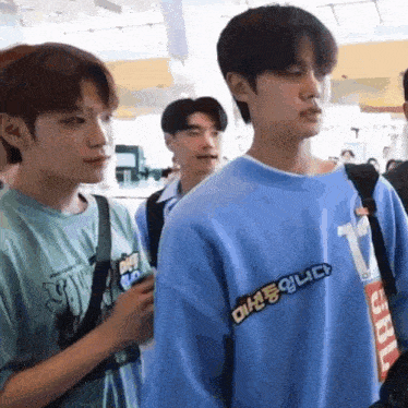 a group of young men are standing next to each other and one of them is wearing a blue sweater with the number 17 on it