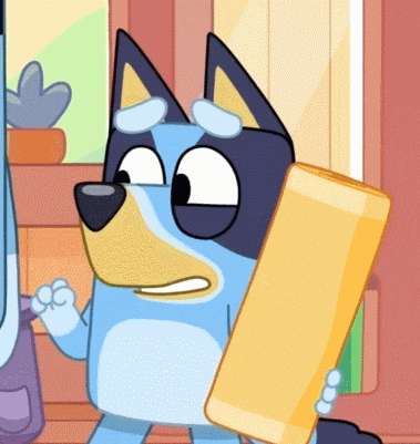 a blue and yellow cartoon dog holding a yellow object in its paws
