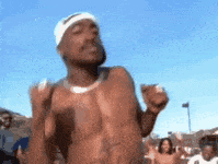 a shirtless man wearing a headband is dancing in front of a crowd .