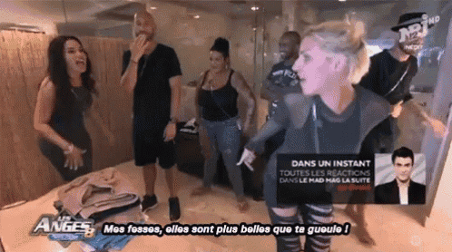 a group of people are standing in a room with a sign that says ' dans un instant ' on it
