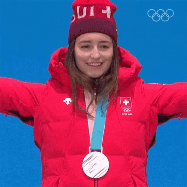 a woman wearing a red jacket and a red hat with the letter h on it